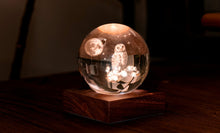 Charger l'image dans la galerie, Veilleuse boule de cristal 3D de Gingko Design avec motif de chouette sous la lune posée sur son socle en bois de noyer illuminé.