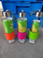 Charger l'image dans la galerie, Trois bouteilles en verre pour infusion d'agrumes, avec bases presse-agrumes de couleur orange, fuchsia et verte, prêtes pour l'eau détox

